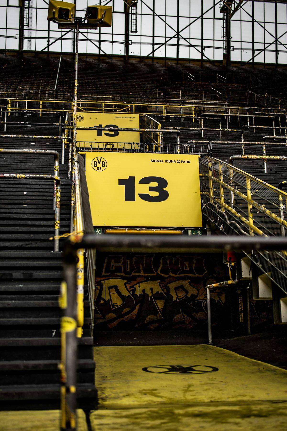 Escalier menant au bloc 13 des tribunes du Signal Iduna Park, le stade du Borussia Dortmund, avec le panneau jaune du BVB